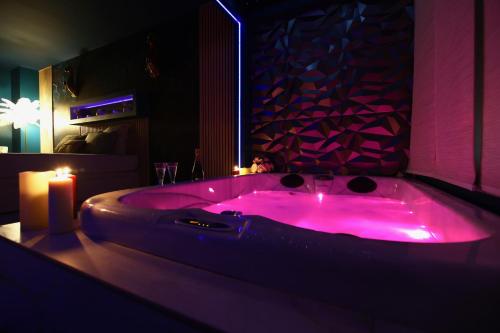 a pink bath tub with a candle in a room at Flower Suite and Spa in La Seyne-sur-Mer