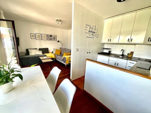 cocina y sala de estar con mesa y sillas. en Apartamento Ría Navia El Espín 31A01, en Navia