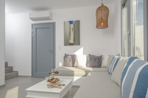 ein weißes Wohnzimmer mit einem Sofa und einem Tisch in der Unterkunft Casa Rakan in Naxos Chora