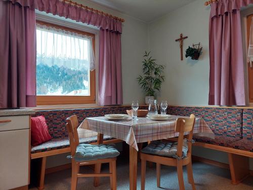 una sala da pranzo con tavolo, sedie e finestra di Ferienwohnung Frieda a Sillian
