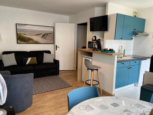 un petit salon avec un canapé et une table dans l'établissement LE BON ENDROIT en bord de mer, vue mer , parking et wifi, à Wimereux