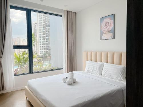 a bedroom with a bed with a teddy bear on it at THE LUMIÈRE RIVERSIDE LUXURY SUITE in Ho Chi Minh City