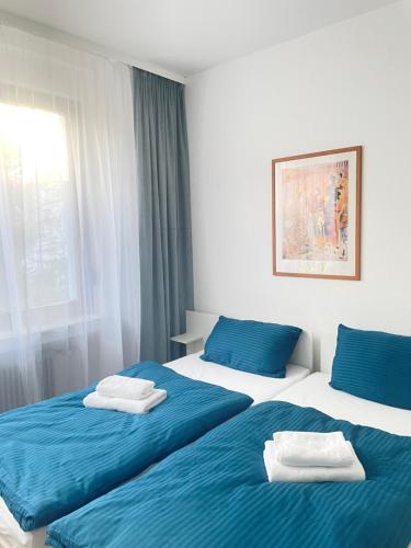 two beds in a room with blue and white at Stay Westend in Wetzlar