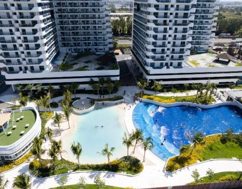 a large swimming pool with palm trees and buildings at Azure North Staycation by 7TwentySix CRIB in San Fernando