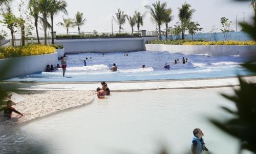 a group of people swimming in a wave pool at Azure North Staycation by 7TwentySix CRIB in San Fernando