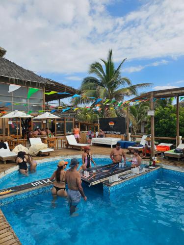 un grupo de personas en la piscina de un complejo en The Point Mancora - Beach Party Hostel, en Máncora