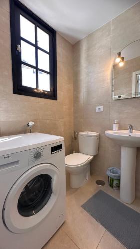 a bathroom with a washing machine and a toilet at Las Fresas Apartments in Puerto Rico de Gran Canaria