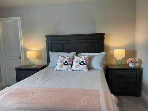 a bedroom with a bed with pillows and two lamps at Spacious and fully equipped family house for 10 in Shenandoah