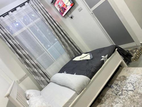 een klein bed in een kamer met een raam bij DODOMA WHITE HOTEL in Dodoma