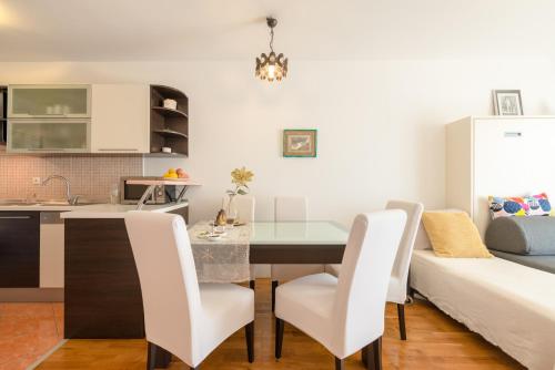 eine Küche und ein Esszimmer mit Tisch und Stühlen in der Unterkunft Comfy & Urban apartment on Žnjan near beach in Split