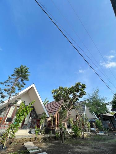 a house with trees in front of it at Meno Melani guesthouse in Gili Meno