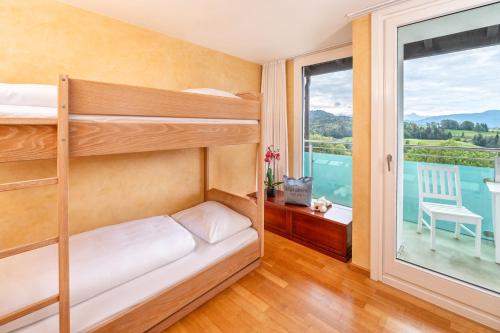 a bedroom with bunk beds and a balcony at AllgäuStern Hotel in Sonthofen