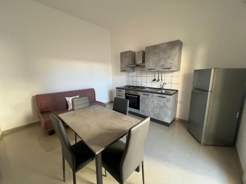 a kitchen with a table and chairs and a refrigerator at Aurora e Alba in Casalabate