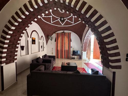 una sala de estar con sofás y un arco en Oriental house en Luxor