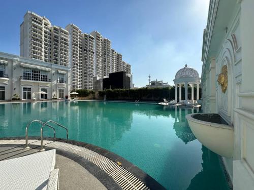 a large swimming pool in a building with tall buildings at Tranquil Manor With Swimming Pool in Lucknow