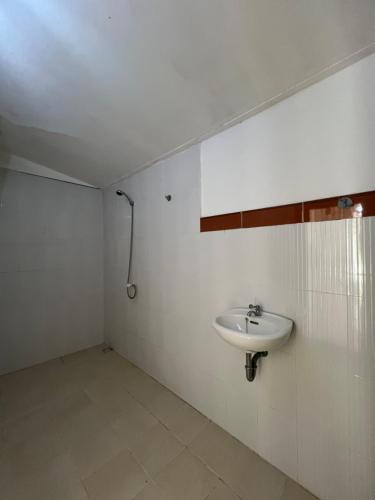 a white bathroom with a sink and a shower at Meno Melani guesthouse in Gili Meno
