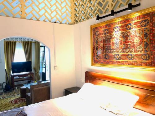 a bedroom with a bed and a large tapestry on the wall at Villa Garden Apart & swimming pool in Kampot