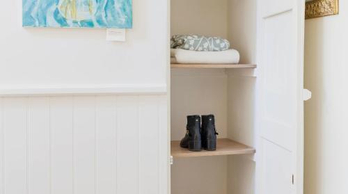 a room with a closet with shoes on shelves at A handsome large 9 bedroom 17th Century village house moments from The Cotswold Way offering modern luxury in a peaceful location in Frocester