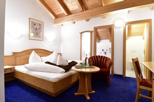 - une chambre avec un lit, une table et une chaise dans l'établissement Hotel Höllroah, à Kappl