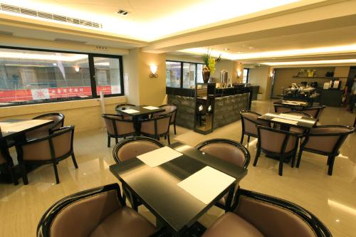 ein Restaurant mit Tischen und Stühlen und eine Bar in der Unterkunft Nest Hotel in Kaohsiung