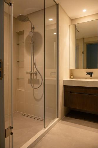 a glass shower in a bathroom with a sink at Beachfront Elegant 2BD Condo with Breathtaking Views -15AB01 in Dubai