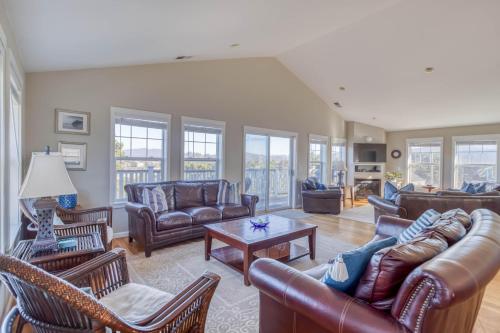 a living room with leather couches and chairs at The Spindrift House in Lincoln City