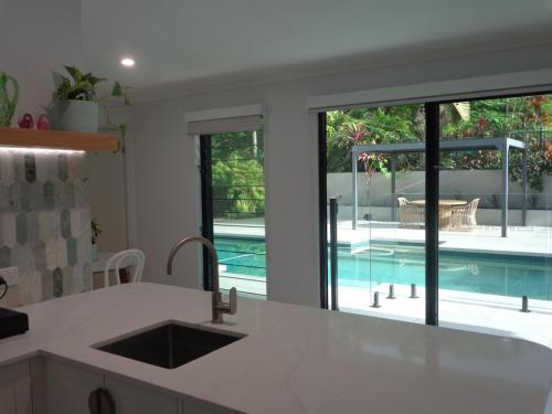 a kitchen with a view of a swimming pool at Noosa Buoys in Tinbeerwah