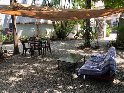 a patio with a table and a bed and a table and chairs at Villa Garden Apart & swimming pool in Kampot