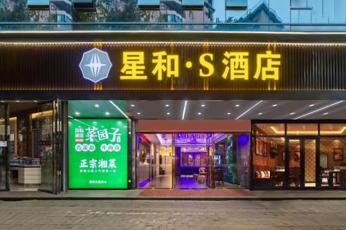 un negozio con un'insegna al neon davanti di Xinghe Yuezhi S Hotel to Guangzhou Yuexiu Park Railway Station Subway Station Baima Clothing City Flagship Store a Canton
