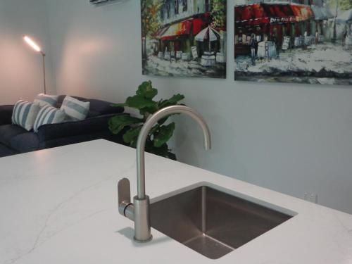 a kitchen sink in a kitchen with a couch at Noosa Buoys in Tinbeerwah