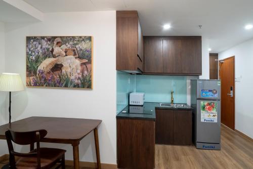 a small kitchen with a table and a refrigerator at Langmandi Hotel & Apartment in Da Nang