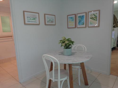 a table with two chairs and a potted plant on it at Noosa Buoys in Tinbeerwah