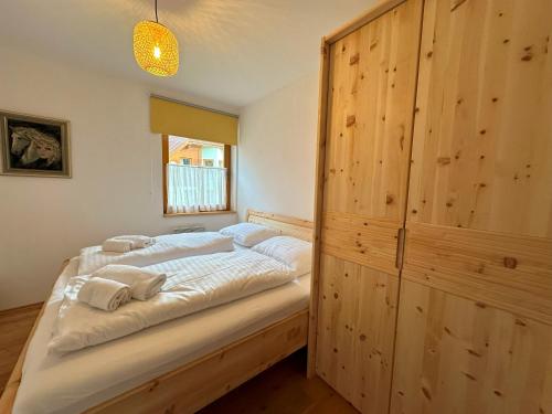 バート・クラインキルヒハイムにあるSKI-TO-DOOR Sonnwieseのベッドルーム1室(ベッド1台、大きな木製キャビネット付)