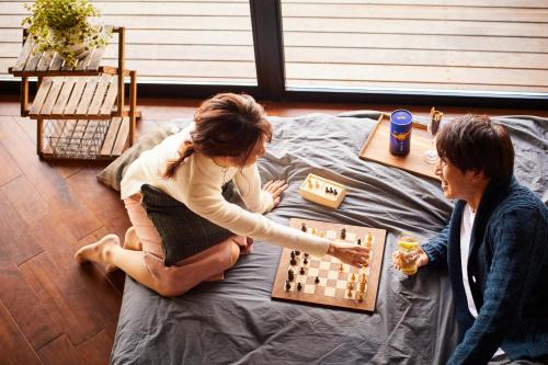 Ein Mann und eine Frau spielen Schach in der Unterkunft COTON special guest house in Kanonji