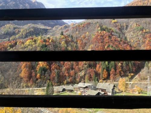 a view from a window of a house in the mountains at Cozy 500 Years Old Walser Home in Alagna Valsesia