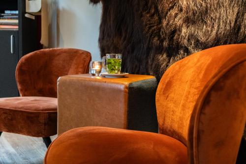 a table with two glasses and two chairs at Kruller - Hotel B&B in Otterlo
