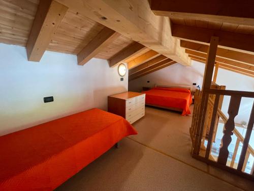 een slaapkamer op zolder met 2 bedden en een trap bij Villa Dascia - Agenzia Cocal in Caorle
