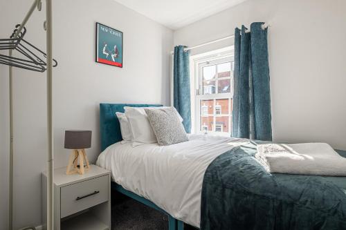 a bedroom with a bed and a window at Our latest stunning property by Our Home Short Stays free parking super fast WiFi large back garden and crisp hotel white linen in Bedford