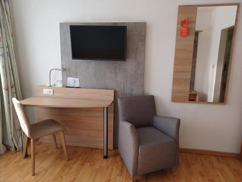 a room with a desk and a chair and a television at Hotel Europa in Bonn