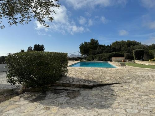 - une piscine avec un bush à côté dans l'établissement Appartement Piscine LA CIOTAT - CEYRESTE, à Ceyreste