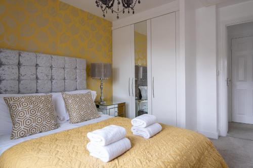 um quarto com uma cama grande e toalhas em Sorrel House em Carterton