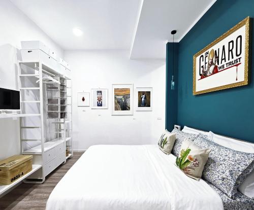 - une chambre avec un lit blanc et un mur bleu dans l'établissement Napulitano Assaje Home, à Naples