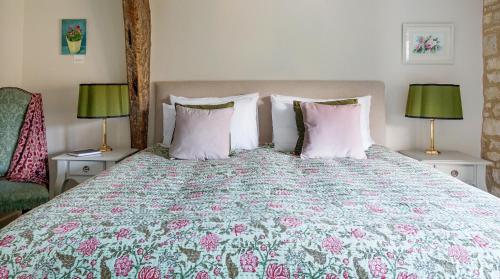 a bedroom with a large bed with two lamps at A handsome large 9 bedroom 17th Century village house moments from The Cotswold Way offering modern luxury in a peaceful location in Frocester