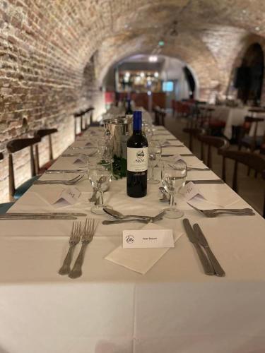 a long table with a bottle of wine and glasses at The Swan Hotel, Alresford in Winchester
