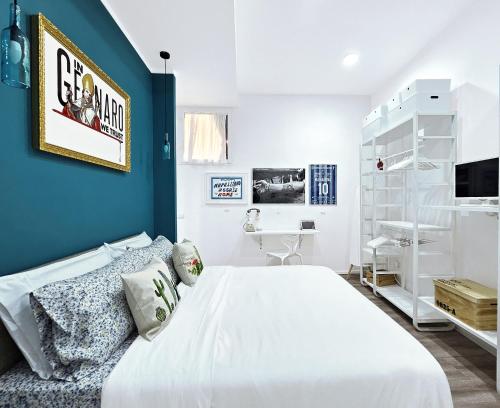 - une chambre avec un lit blanc et un mur bleu dans l'établissement Napulitano Assaje Home, à Naples