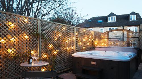 a bathroom with a tub on a fence with lights at A handsome large 9 bedroom 17th Century village house moments from The Cotswold Way offering modern luxury in a peaceful location in Frocester