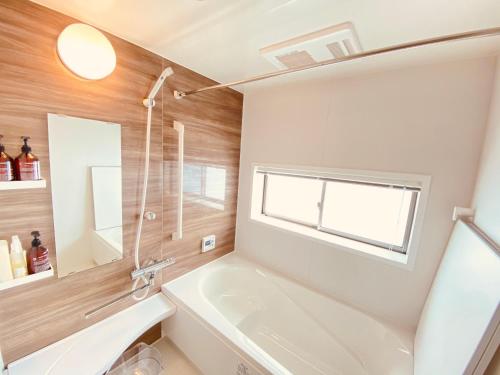 La salle de bains est pourvue d'une baignoire, d'un lavabo et d'une fenêtre. dans l'établissement hale uka, à Inbu