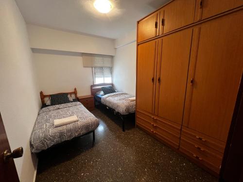 um pequeno quarto com uma cama e um armário em HABITACIÓN CÉNTRICA EN ACOGEDORA CASA em Valência
