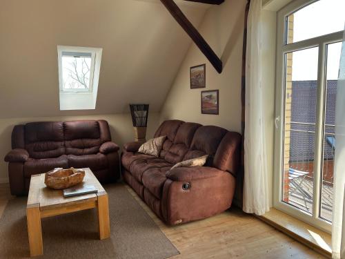 a living room with a brown leather couch and a table at Ölmühle Eberstedt in Eberstedt