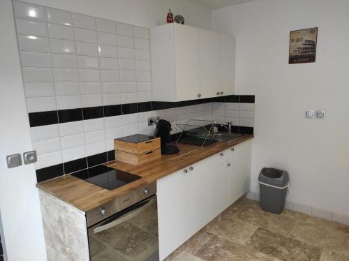 a kitchen with white cabinets and a wooden counter top at maison luxe cléo aeroport tillé 4 personnes in Tillé